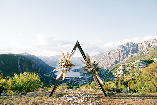 Wedding teepee arch stands on the mountain above the Kotor Bay valley. Montenegro. High quality photo