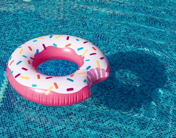 istock Pink inflatable donut swimming ring in a swimming pool 1911985881