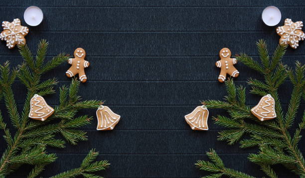 istock Symmetrical New Year's composition. Gingerbread, Christmas tree branches and candles are on a background of dark paper. Layout for the design. A place for the text. Flat Lay. Top View 1912001824