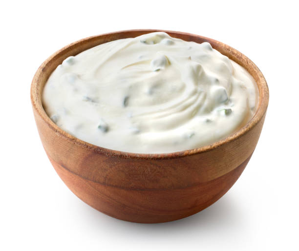 Wooden bowl of fresh sour cream dip sauce with herbs Wooden bowl of fresh sour cream dip sauce with herbs isolated on white background ranch stock pictures, royalty-free photos & images