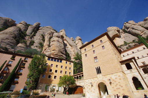 Montserrat, Spain-October,31. 2023: Montserrat is located 20 km northwest of Barcelona.
In Catalan, it means a jagged mountain that looks like a saw.
The highest peak is over 1200 meters above sea level.
The Benedictine Abbey of St. Mary is located at an altitude of over 700 meters.Legend has it that a statue of the Black Virgin of Montserrat appeared in a cave in the mountain. Because of the many miracles of the Black Mary, Montserrat became a sacred place, and the Black Mary became the patron saint of Catalonia.