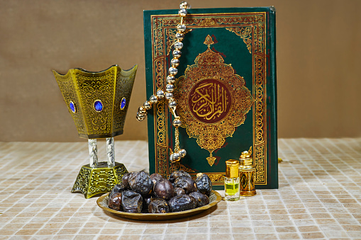 holy book of Muslims and oud perfume and censer, dates fruit, tasbih