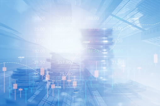 Percentage sign on top of coin stacks before blue financial graph. Horizontal composition with copy space. Business and finance concept.