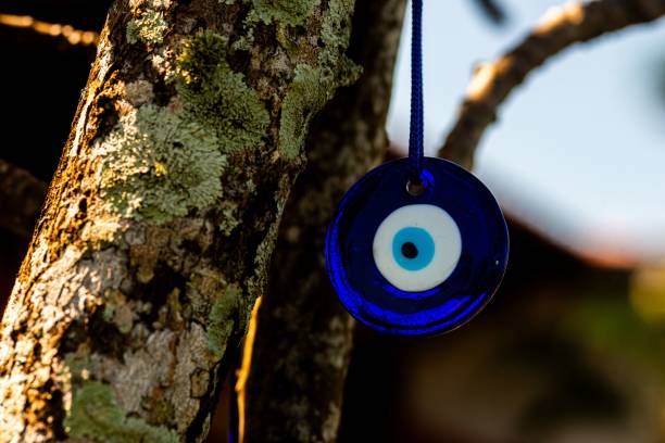 istock an evil eye hanging from a tree branch at the end of day 1912110353