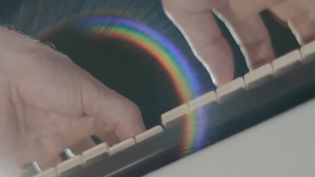 A man plays on a synthesizer keyboard (piano) bottom view