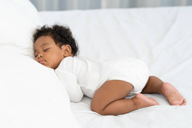 istock black african american baby sleeping on a white mattress. 1912182825