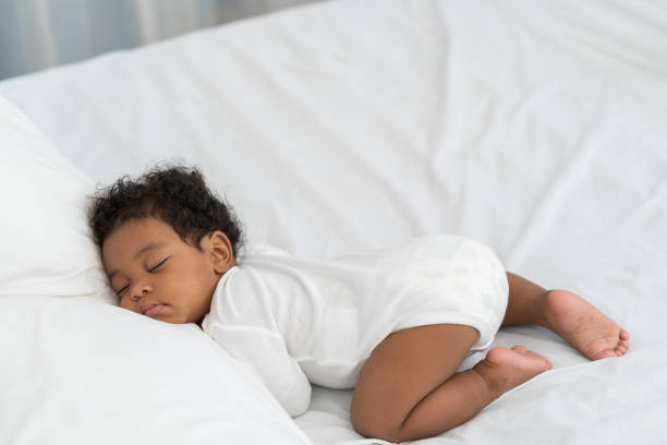 istock black african american baby sleeping on a white mattress. 1912186643