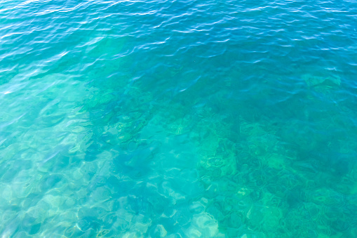 Clean transparent sea water, lake bottom and sand. Beautiful blue, turquoise transparent surface background