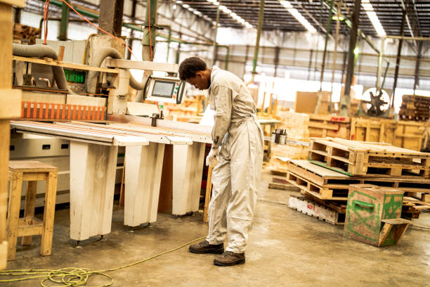 istock African man workers engineering standing with confidence with working suite dress and hand glove in front machine. Concept of smart industry worker operating. Wood factory produce wood palate. 1912227143