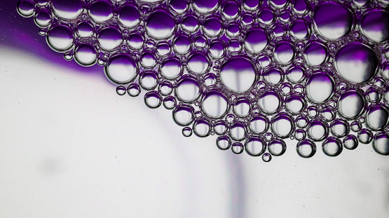 Abstract purple-graded water background and transparent soap bubble pattern. Water soap bubble background close up with macro shot