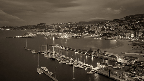 Aerial view of Sanremo at night, Italy. Port and city buildings.