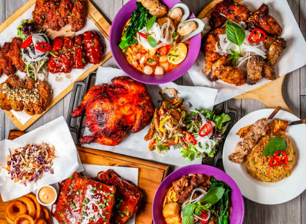 istock Garlic fried rice, skewer, whole grilled chicken, peri peri, fried wings platter, beef noodle soup, seafood laksa and US baby back ribs served isolated on wooden table top view of hong kong food 1912320552