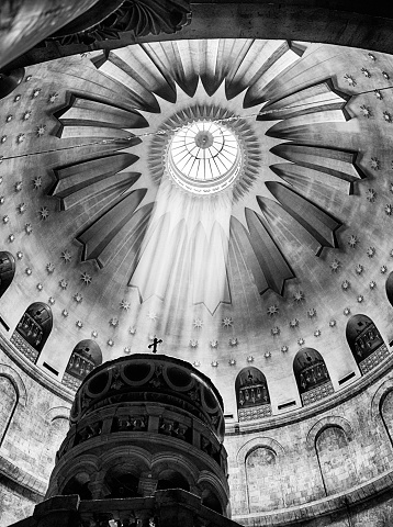 God rays in black and white from the dome appear to beam directly at the Aedicule shrine in the center of the main rotunda of the Church of the Holy Sepulchre in Jerusalem.