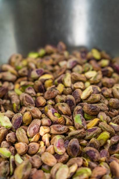 istock White ceramic bowl containing several large, peeled pistachio nuts, ready to be cooked in the oven 1912356878