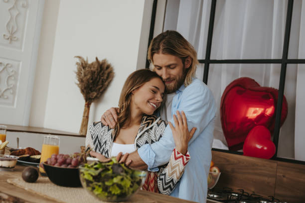 istock Young romantic couple embracing while celebrating Valentines day at the domestic kitchen together 1912357928