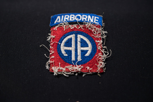 Saint Mere Eglise, France – October 14, 2023: Detail of a worn patch of the 82nd Airborne Division on a black background