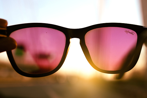 View through rose-colored glasses against blue sky