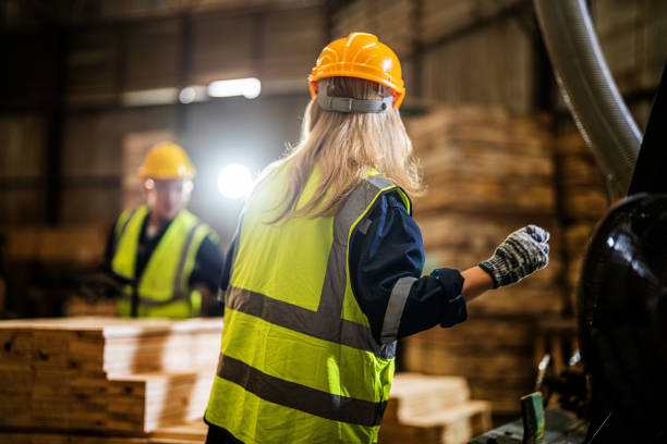 istock Team worker carpenter wearing safety uniform and hard hat working and checking the quality of wooden products at workshop manufacturing. man and woman workers wood in dark warehouse industry. 1912400147
