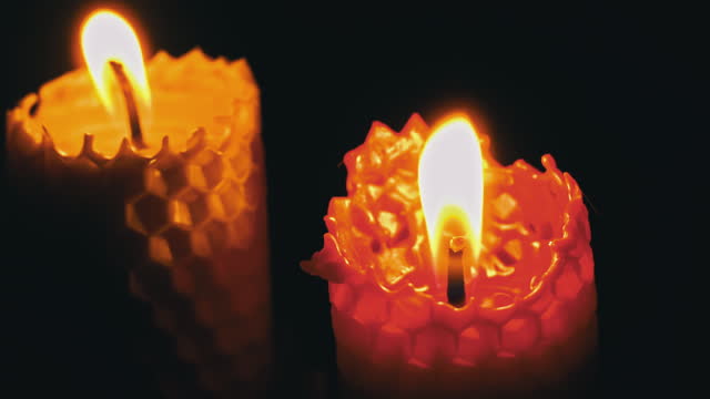 Two Wax Candles Burn on Black Background