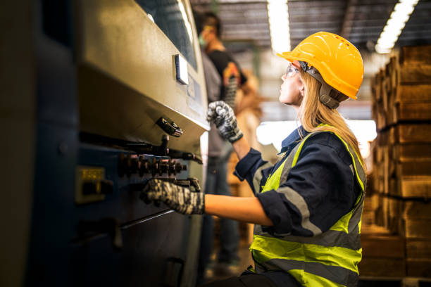 istock Factory engineer woman standing confidence to control panel switch. Worker works at heavy machine at industry factory. with machinery equipment plant technology. smart industry worker operating. 1912424033