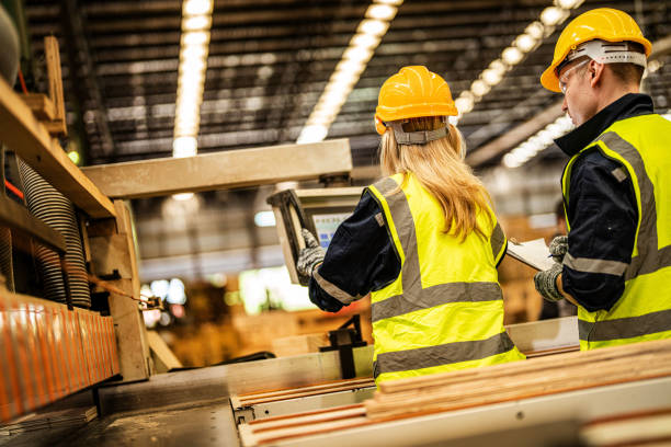 istock back of Factory engineer workers standing to control panel switch. people works at heavy machine at industry factory. with machinery equipment plant technology. smart industry worker operating. 1912428660