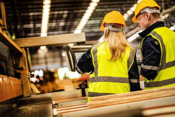istock back of Factory engineer workers standing to control panel switch. people works at heavy machine at industry factory. with machinery equipment plant technology. smart industry worker operating. 1912441072