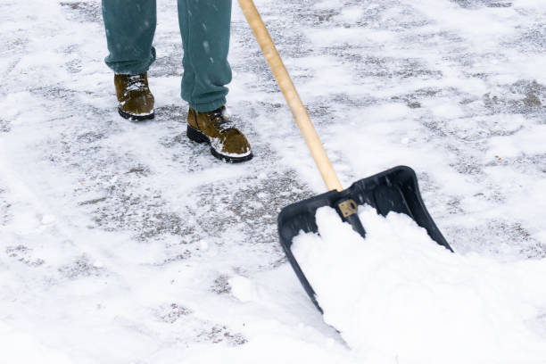 istock an unrecognizable man cleans snow with a shovel in a snowfall. close-up 1912447401