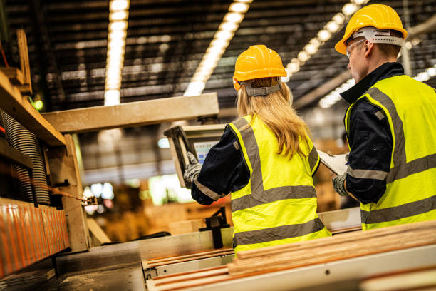 istock back of Factory engineer workers standing to control panel switch. people works at heavy machine at industry factory. with machinery equipment plant technology. smart industry worker operating. 1912451603