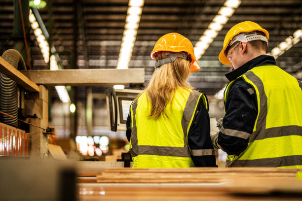 back of Factory engineer workers standing to control panel switch. people works at heavy machine at industry factory. with machinery equipment plant technology. smart industry worker operating.