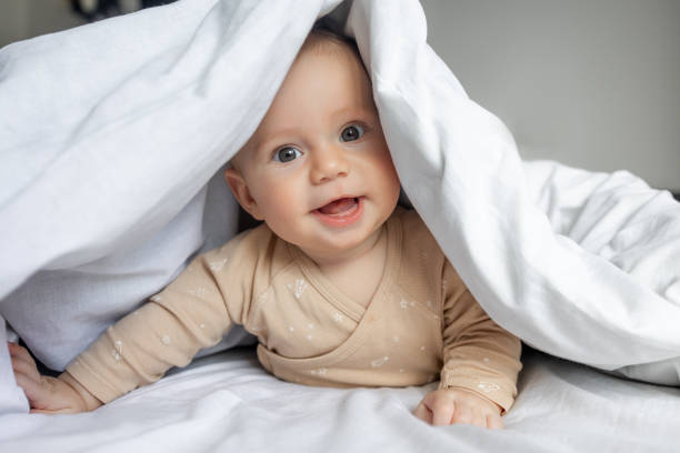 istock baby boy is hiding under the white blanket 1912468440