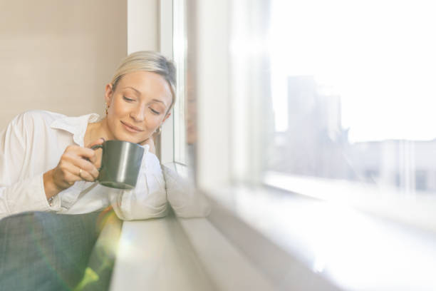 istock A young woman enjoying coffee time by the window 1912474649
