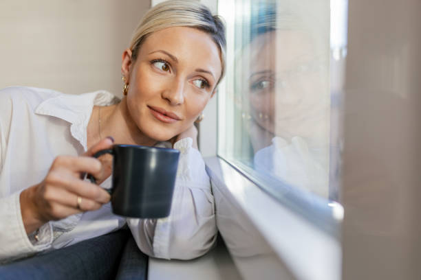 istock A young woman enjoying coffee time by the window 1912474650