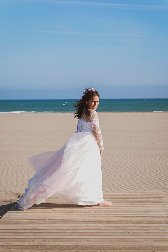Girl on the beach after her communion, expressing her Christian faith.