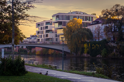 Ulm, Germany  - November 1, 2023: Early morning at the Danube river in Ulm, Germany. Colorful cityscape with modern buildings in a green environment.