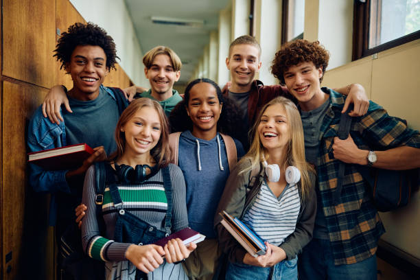 istock Multiracial group of happy classmates at high school hallway looking at camera. 1912511513