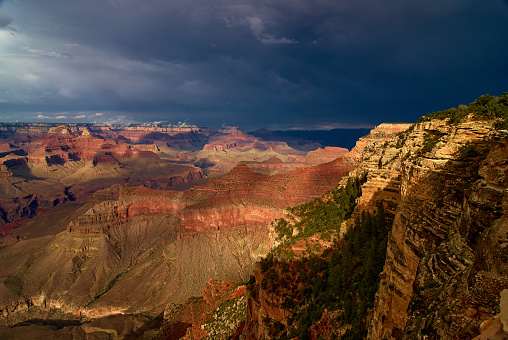 Beautiful sunset view of the Grand Canyon from the south rim trail near Yavapai Point at the end of a stormy day in Arizona, USA.
