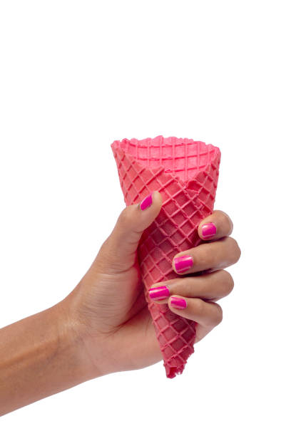 istock Woman's hand holding empty wafer pink cone for ice cream. Close up, High resolution product 1912568003