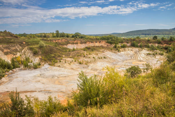 istock Old closed quarry. Puddles in an old quarry. Trees growing over geological structures of hercynian orogeny inside of old closed quarry in mountains in Ukraine 1912643351