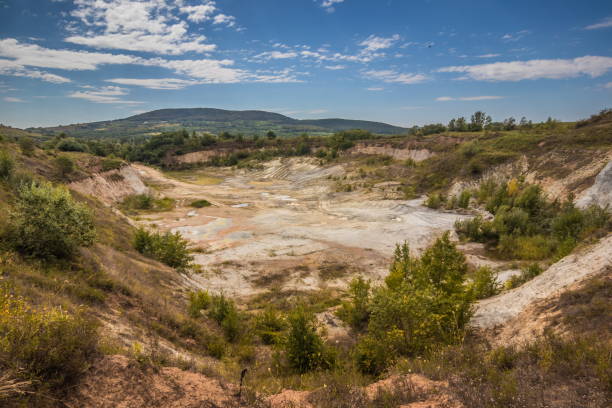 istock Old closed quarry. Puddles in an old quarry. Trees growing over geological structures of hercynian orogeny inside of old closed quarry in mountains in Ukraine 1912643873