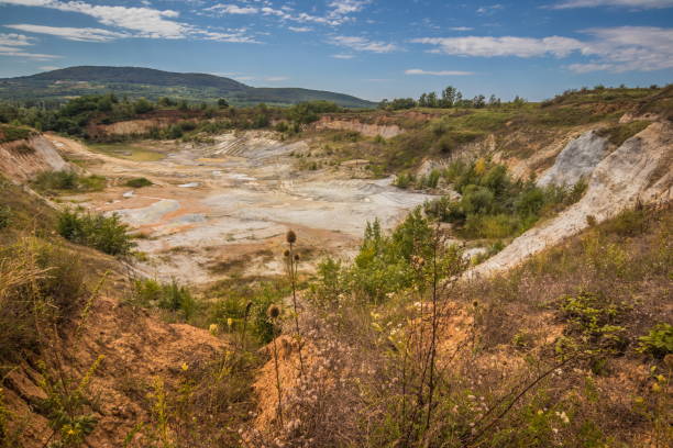 istock Old closed quarry. Puddles in an old quarry. Trees growing over geological structures of hercynian orogeny inside of old closed quarry in mountains in Ukraine 1912643879