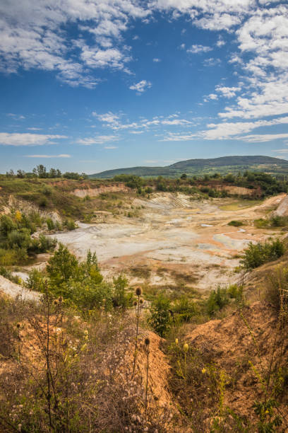 istock Old closed quarry. Puddles in an old quarry. Trees growing over geological structures of hercynian orogeny inside of old closed quarry in mountains in Ukraine 1912644382