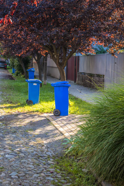 istock Blue garbage cans on the street in a small town near every house. Centralized garbage collection in a small cozy European city. Garbage collection on a certain day of the week. 1912651167