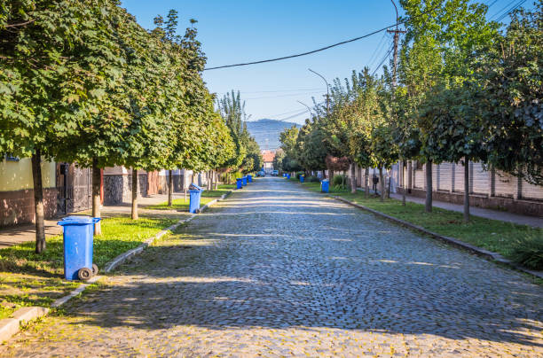 istock Blue garbage cans on the street in a small town near every house. Centralized garbage collection in a small cozy European city. Garbage collection on a certain day of the week. 1912652199