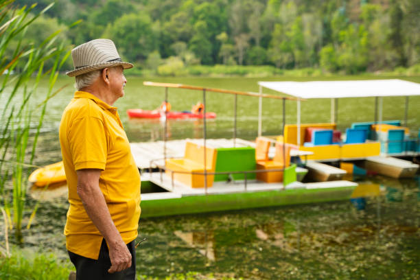 grandfather between 60 and 70 years old at the boat dock, looking at the horizon enjoying his retirement