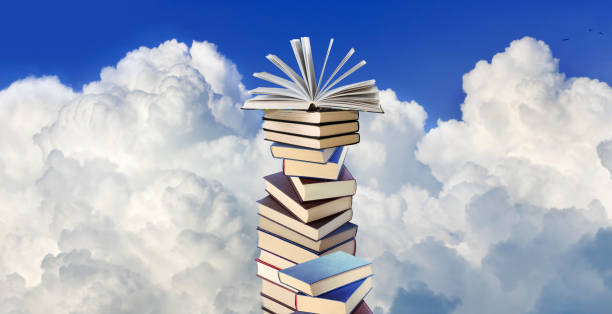 istock stack of books with an open book lying on top of the stack against a background of white clouds 1912714280