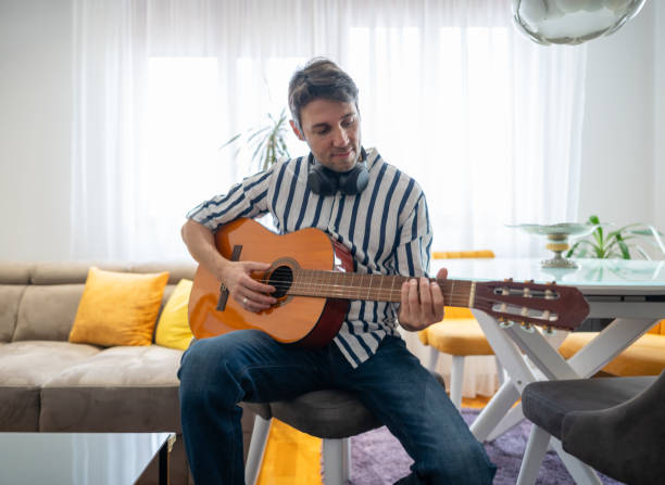 istock Man playing acoustic guitar at his apartment 1912820930