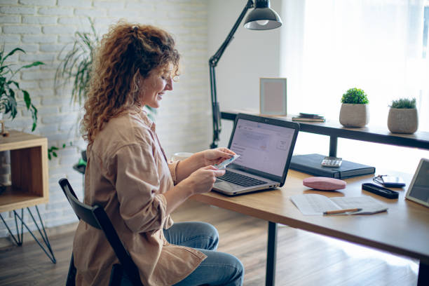 istock Young woman doing her finances at home and is happy about it 1912854012