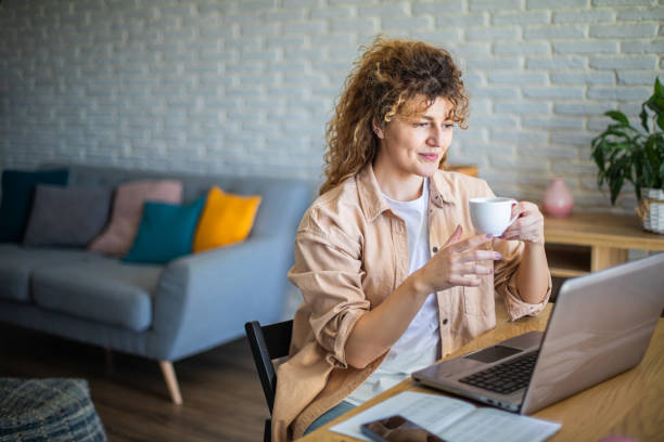 istock Young female entrepreneur working on a laptop and drinking coffee 1912863643