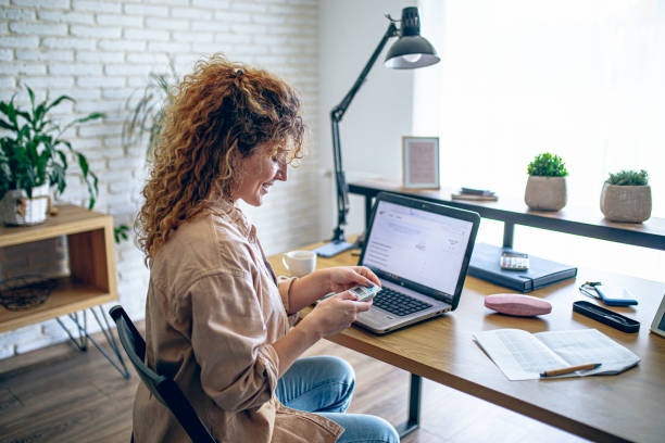 istock Young woman doing her finances at home and is happy about it 1912865503