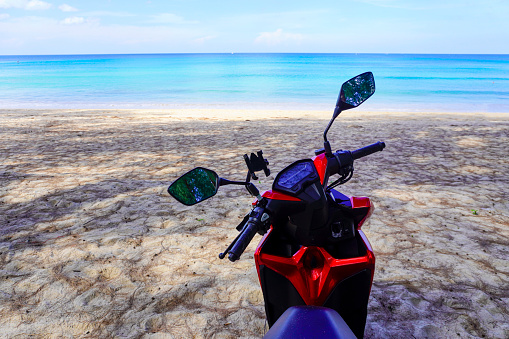 motorbike on the beach in Thailand. Blue sea and yellow sand. There is space for text for your advertisement